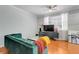 Living Room with a large green velvet couch, wood floors, and a large screen tv at 860 N Orange Ave # 226, Orlando, FL 32801