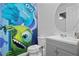 Whimsical bathroom boasts a gray vanity and a themed wall mural for a playful touch at 8953 Amelia Downs Trl, Kissimmee, FL 34747