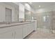 Elegant bathroom with double vanity, white cabinetry, quartz countertop, and a spacious glass-enclosed shower at 8953 Amelia Downs Trl, Kissimmee, FL 34747