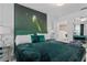Themed bedroom is furnished with a luxurious green bed, a glam nightstand, and statement wall art at 8953 Amelia Downs Trl, Kissimmee, FL 34747