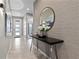 Welcoming entryway with modern console table, round mirror, and stylish decor, leading to a bright interior at 8953 Amelia Downs Trl, Kissimmee, FL 34747