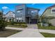 Charming two-story home with a modern blue exterior, stone accents, manicured landscaping, and a paved driveway at 8953 Amelia Downs Trl, Kissimmee, FL 34747