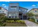 Modern two-story home with stone accents, manicured landscaping, and a paver driveway under a bright blue sky at 8953 Amelia Downs Trl, Kissimmee, FL 34747