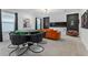 Fun game room with poker table, comfortable orange sofa, and sports themed decor at 8953 Amelia Downs Trl, Kissimmee, FL 34747