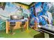 Unique game room with dual monitors, vibrant Avatar themed wall art, and turf flooring at 8953 Amelia Downs Trl, Kissimmee, FL 34747