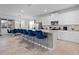 Bright kitchen featuring a large island with seating, white cabinets, stainless steel appliances, and an adjacent dining area at 8953 Amelia Downs Trl, Kissimmee, FL 34747