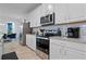 Modern kitchen featuring white cabinets, stainless steel appliances, and ample counter space for meal preparation at 8953 Amelia Downs Trl, Kissimmee, FL 34747