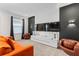 Stylish living room features a comfortable orange sofa and a wall mounted television at 8953 Amelia Downs Trl, Kissimmee, FL 34747