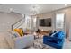 Inviting living room with a staircase, stylish furnishings, large windows, and a modern entertainment center at 8953 Amelia Downs Trl, Kissimmee, FL 34747