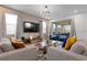 Cozy living room with a neutral color palette, comfortable seating, large windows, and a modern entertainment center at 8953 Amelia Downs Trl, Kissimmee, FL 34747