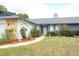 Charming home with front lawn landscaping, walkway, and covered entry at 9311 Sonia St, Orlando, FL 32825