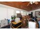 Sunroom filled with boxes, storage containers and furniture with tongue-and-groove ceiling at 9311 Sonia St, Orlando, FL 32825
