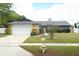 Charming single-story home featuring a two-car garage, stone accents, and a lush green lawn at 9311 Sonia St, Orlando, FL 32825