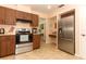 Well-lit kitchen with stainless steel oven, refrigerator, and wood cabinetry at 9311 Sonia St, Orlando, FL 32825