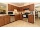 Kitchen with stainless steel appliances, wooden cabinetry, and tile floors at 9311 Sonia St, Orlando, FL 32825