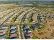 Aerial view of a residential neighborhood showcasing homes, streets, and community layout with a large lake in the distance at 970 Timberview Rd, Clermont, FL 34715