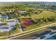 Aerial view of the community basketball court, parking area, clubhouse, and pool in a lushly landscaped setting at 970 Timberview Rd, Clermont, FL 34715
