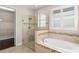 Bright bathroom featuring glass enclosed shower, soaking tub and walk-in closet at 970 Timberview Rd, Clermont, FL 34715