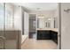Bright bathroom with double vanities, neutral tile, walk-in closet and separate glass shower at 970 Timberview Rd, Clermont, FL 34715
