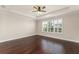 Empty bedroom featuring tray ceilings, plantation shutters, and hardwood floors at 970 Timberview Rd, Clermont, FL 34715