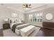 Staged primary bedroom with natural lighting, tray ceilings, and a warm color palette at 970 Timberview Rd, Clermont, FL 34715
