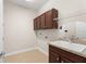 Functional laundry room with cabinets, a sink, and plenty of counter space at 970 Timberview Rd, Clermont, FL 34715