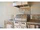 Outdoor kitchen area boasts stainless steel grill, granite countertop, and stone accents for stylish outdoor cooking at 970 Timberview Rd, Clermont, FL 34715