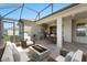 Covered patio with built in kitchen and dining and seating area with fire pit at 970 Timberview Rd, Clermont, FL 34715