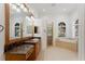 Bright bathroom with double windows, a soaking tub, a glass enclosed shower and granite vanity at 9907 Beaufort Ct, Windermere, FL 34786
