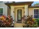 Covered front entrance with meticulously landscaped foliage and glass paneled door at 9907 Beaufort Ct, Windermere, FL 34786