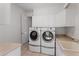 Well-lit laundry room with white cabinets, utility sink and modern washer and dryer at 9907 Beaufort Ct, Windermere, FL 34786
