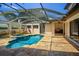 Aerial view of screened-in pool, spa and patio with outdoor kitchen and lush landscaping at 9907 Beaufort Ct, Windermere, FL 34786