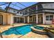 An aerial view of the home's screened in pool, spa, and patio with stone surround at 9907 Beaufort Ct, Windermere, FL 34786