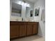 Dual sink bathroom with expansive mirrors offering practical elegance and style at 9978 Tivoli Villa Dr, Orlando, FL 32829