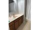 Neutral bathroom with a white countertop vanity, wooden cabinets, large mirror and a shower with a white curtain at 9978 Tivoli Villa Dr, Orlando, FL 32829