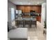 Well-lit kitchen with stainless appliances, wood cabinets, granite counters, and an eat-in bar with seating at 9978 Tivoli Villa Dr, Orlando, FL 32829