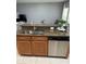 Kitchen island with stainless steel dishwasher and sink, granite counters, and wood cabinets at 9978 Tivoli Villa Dr, Orlando, FL 32829