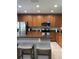 Well-lit kitchen with stainless appliances, wood cabinets, granite counters, and an eat-in bar at 9978 Tivoli Villa Dr, Orlando, FL 32829
