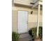 Close up of front door to condo unit showcasing outdoor lighting, building materials, and landscaping at 1001 Spring Meadow # 1001, Kissimmee, FL 34741