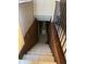 Staircase leading downstairs with wooden railing and tile flooring at 1001 Spring Meadow # 1001, Kissimmee, FL 34741