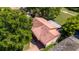 Aerial view of a home with a tile roof, mature trees, and a well-kept lawn at 10423 Manassas Cir, Orlando, FL 32821