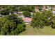 Aerial view of single-story home nestled among mature trees with a well-manicured lawn at 10423 Manassas Cir, Orlando, FL 32821