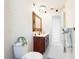 Bathroom featuring a white tiled shower, vanity with wood cabinets, and a decorative mirror at 10423 Manassas Cir, Orlando, FL 32821