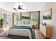 Bright bedroom featuring a ceiling fan, hardwood floors, french doors, and two windows with views at 10423 Manassas Cir, Orlando, FL 32821