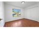 Bright bedroom featuring wood-look floors, a large window, and a double-door closet at 10423 Manassas Cir, Orlando, FL 32821