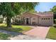 Charming single-story home featuring mature landscaping, a red tile roof, and a inviting front entrance at 10423 Manassas Cir, Orlando, FL 32821