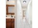 Hallway leading to a bathroom with a dark wood vanity and white tile walls at 10423 Manassas Cir, Orlando, FL 32821