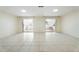 Bright living room features double sliding glass doors, ceramic tile flooring, and neutral walls at 10423 Manassas Cir, Orlando, FL 32821