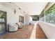 Inviting screened patio with tiled floor, white armchairs, and view of lush backyard at 10423 Manassas Cir, Orlando, FL 32821
