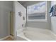 A bathtub sits near a shower stall and a window with blinds, offering a serene bathing experience at 10435 Eastpark Lake Dr, Orlando, FL 32832
